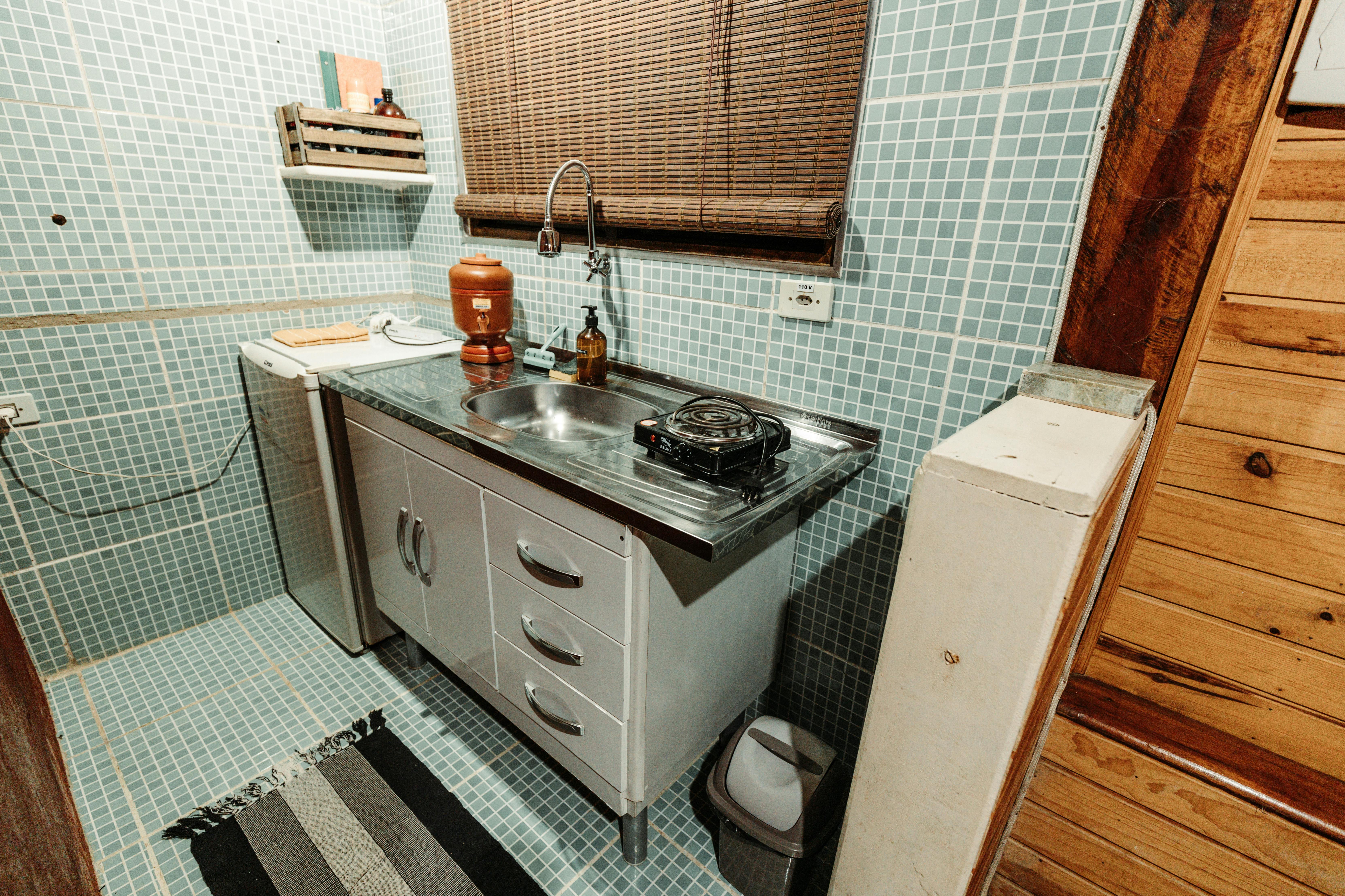 A small yet stylish kitchen featuring a sleek metal sink and minimalist decor, perfect for urban living.