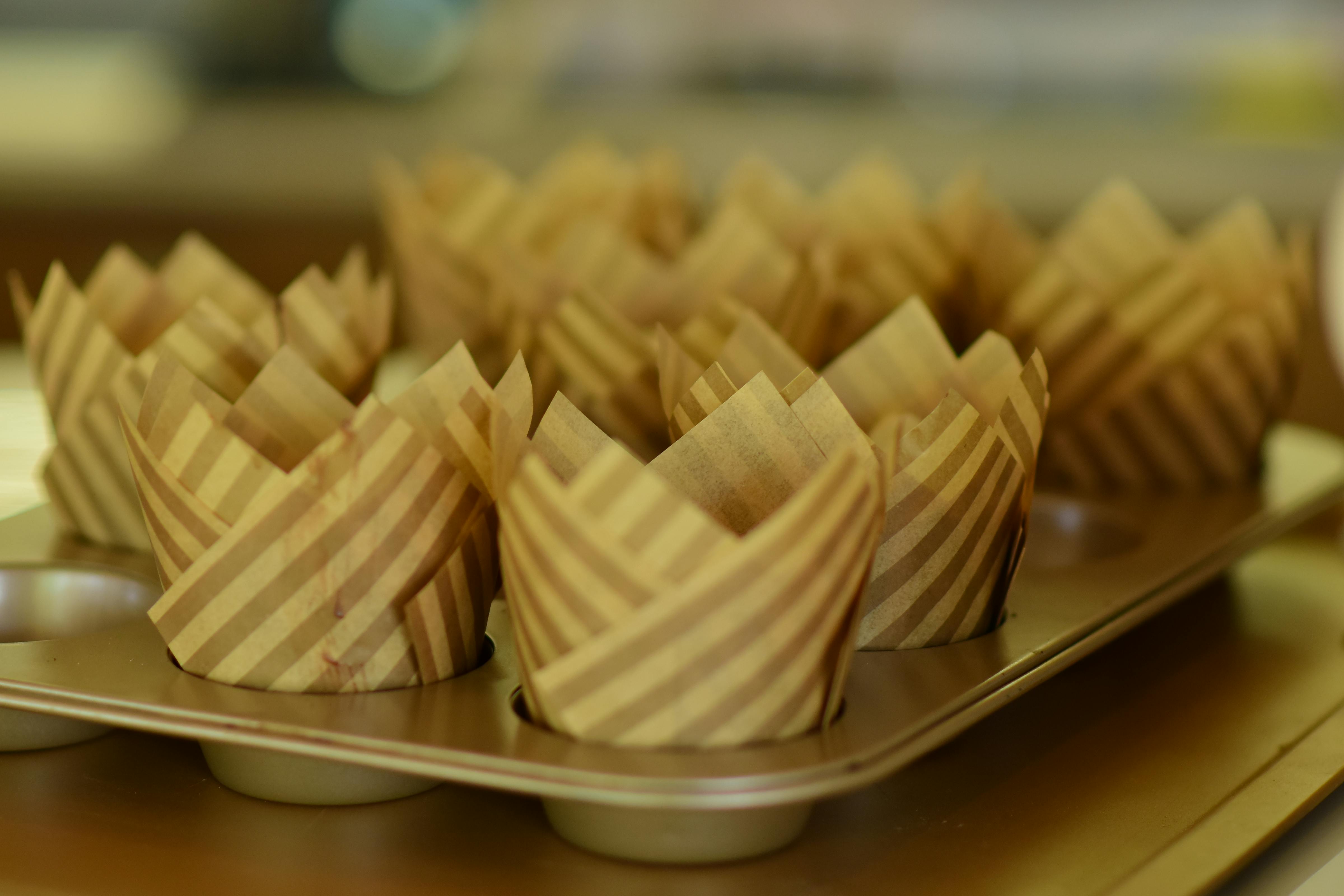Empty stripe-patterned muffin cups lined up in a baking tray, ready for use.